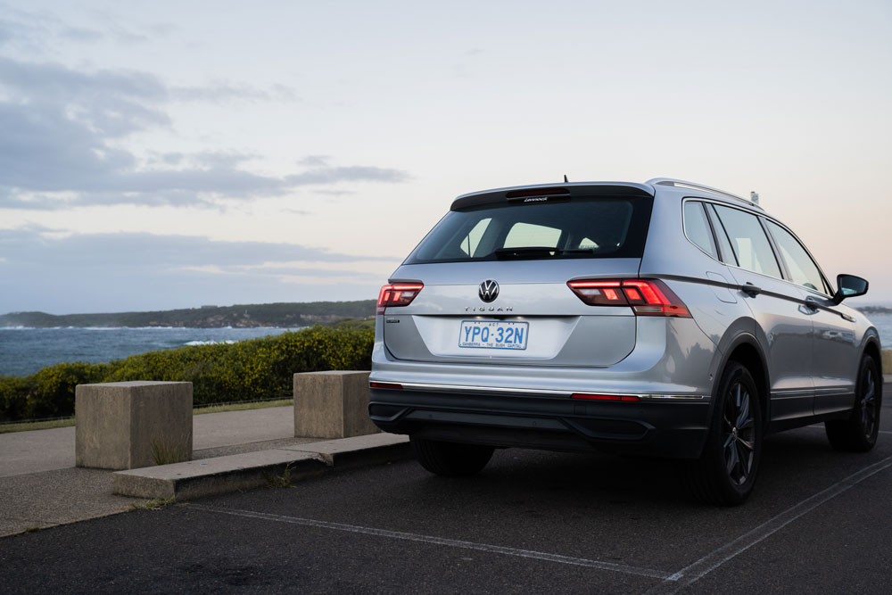 A silver Volkswagen Tiguan SUV parked in a carpark overlooking the ocean