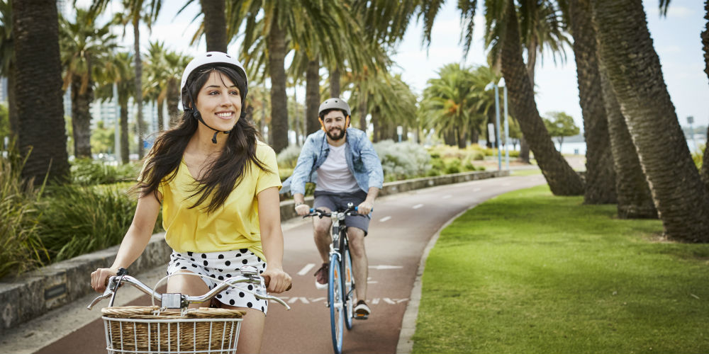 Couple riding bikes along the Swan River