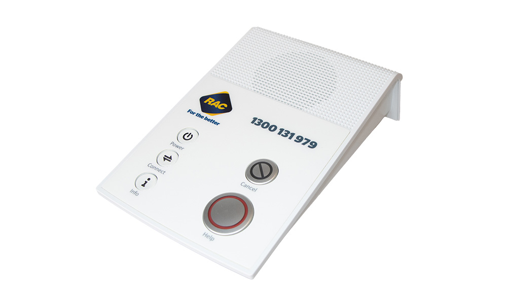 The RAC Personal Alarm Home unit sitting on a bench top.