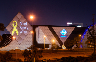 RAC Arena at night time with National Road Safety Week ribbon projected on it