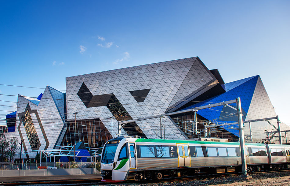 A Transperth train is travelling in front of the RAC Arena