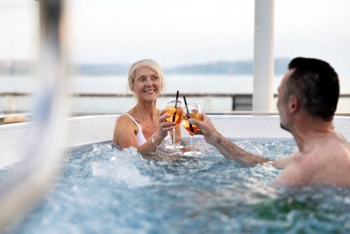 A couple sitting in the spa aboard the Havila cruise ship enjoying a drink