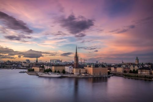 View of Stockholm at sunset with colourful clouds reflecting in the water.