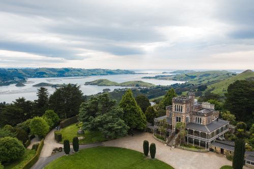 Larnach Castle in Dunedin in the middle of greenery and river land 