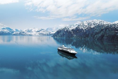 The Holland America vessel in Alaskan icy waters with snowy mountains in the backgorund