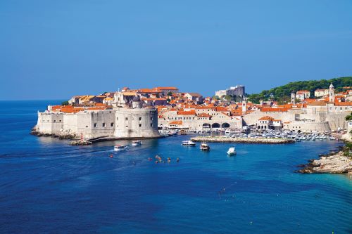 Coastline of Dubrovnik old city surrounded by dark blue sea and clear blue sky. 