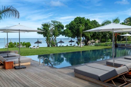 Sunlounges by the pool overlooking the lawn and ocean