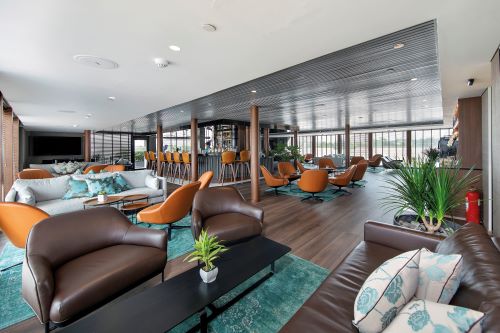 A modern lounge area with sleek furniture, large windows, and a relaxed atmosphere.