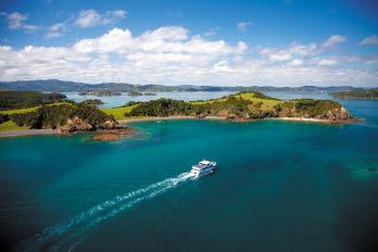 A small boat cruising through New Zealand's Bay of Islands