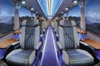 Interior of the Ultimate Coach with comfortable leather seats, all window seats with a side table for each passenger 