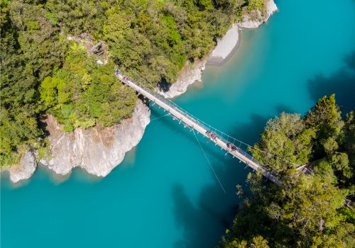 Top down view of a bridge over the blue waters of Hokitika Gorge