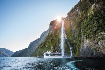 Cruise boat coming close to the Bowen Falls in Milford Sound
