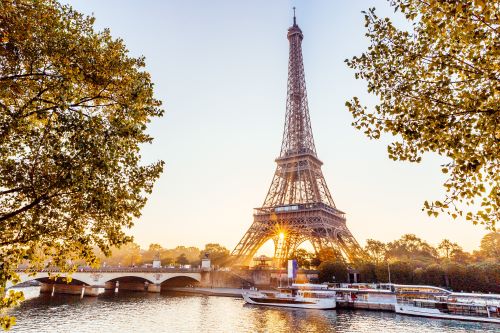 Some ferries on the Seine parked in front of the Eiffel Tower 