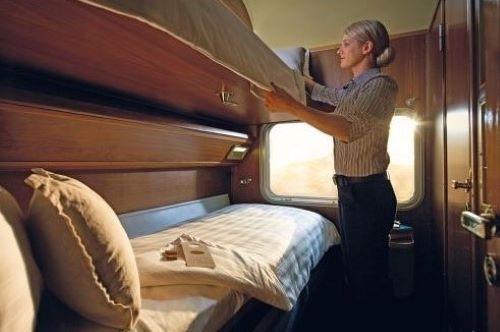 A Journey Beyond attendant is setting up the bunk beds in the Gold Twin Cabin for the night