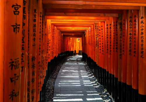 Fushimi Inari-Taisha Shrine with its vibrant red torii gates forming an archway 