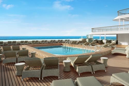 The pool deck aboard NCL's vessel with some sun lounges spread around the pool and the wide ocean in the background