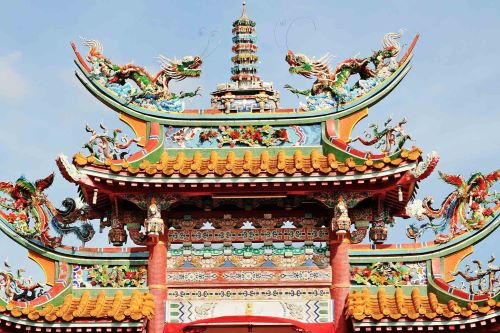 The beautiful, detailed architecture of a colourful temple with dragon sculptures on the roof