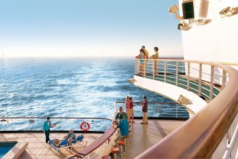 Three tiers of a cruise ship all overlooking the back of the ship with people hanging out in the sunshine enjoying the views of the sea