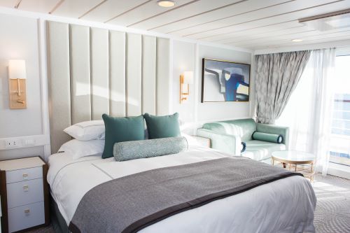 The interior of the Penthouse Suite aboard the Oceania vessel kept in contemporary design with white, turquoise and grey shades. 