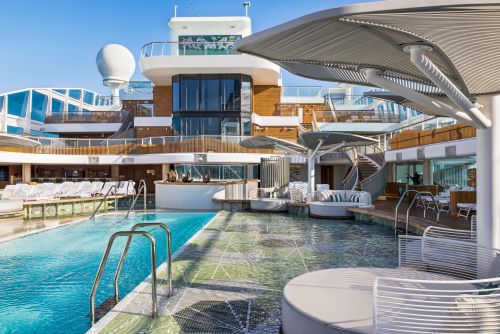 The pool deck aboard an Oceania vessel with lots of sun lounges and beds kept in a contemporary style