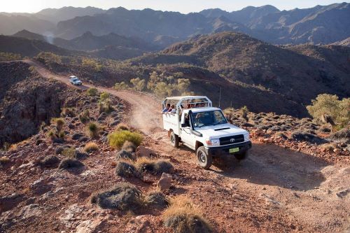 Two Arkaroola 4-wheel-drives driving up a 4WD track on a Flinders Ranges and Outback Ridgetop Tour