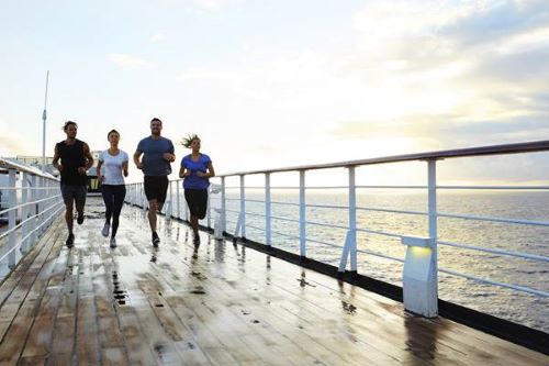 Some passengers running along the exercise track aboard the P&O vessel with the ocean in the background 