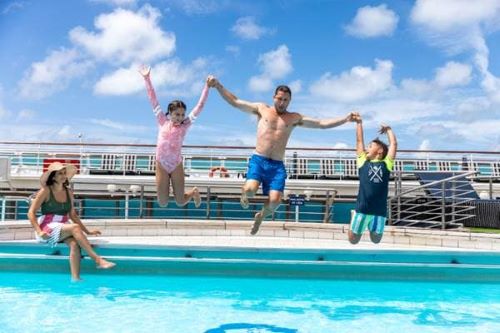 Dad with two kids jumping in the pool onboard a P&O vessel