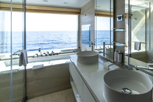 A cabin onboard a cruise ship showing light interiors and a view of the ocean