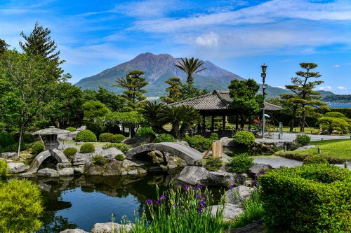 Kagoshima in Japan with a mountain in the background and green gardens in the front