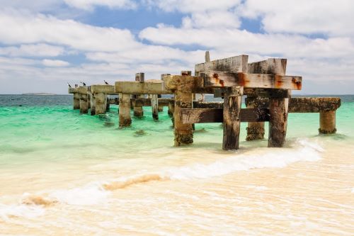 The reminants of an old jetty in the blue waters of the beach