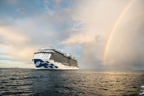 A princess cruise ship at sea with a rainbow showing in the sky