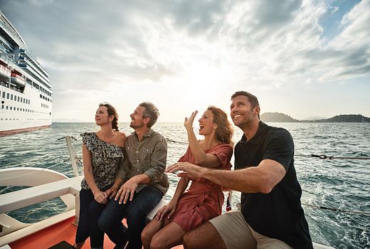 Two couples sitting in a tender boat cruising away from the cruise ship and having a good time