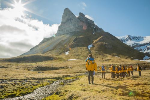 Quark Expeditions passengers hiking up Alkhornet mountain in sunny conditions 