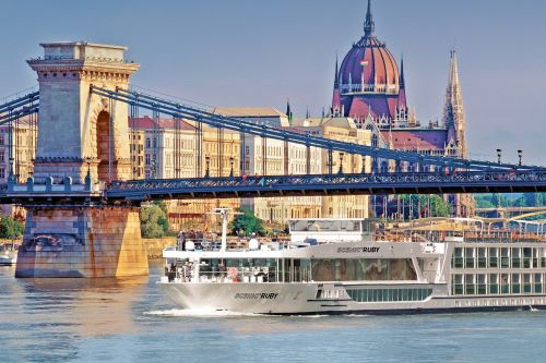 The Scenic vessel going down the river with the Budapest skyline in the background
