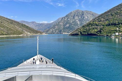 People standing at the bow of Emerald Azzurra while cruising into Kotor Bay