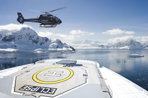The Scenic helicopter landing on the heli deck of the vessel with the icy Antarctic in the background 