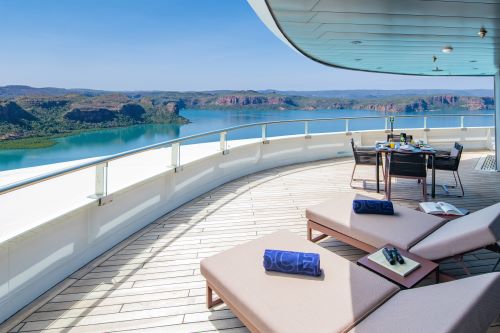 Panorama terrace aboard Scenic vessel featuring two sun lounges and a table to enjoy the view 