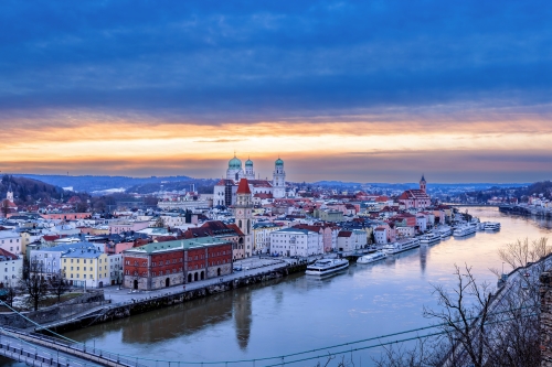 A European city by a river surrounded by winter scenery