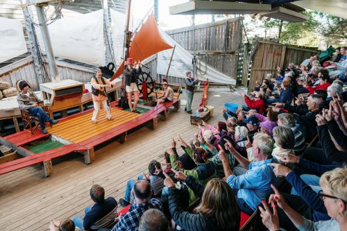 People watching an interactive play about pirates on a ship