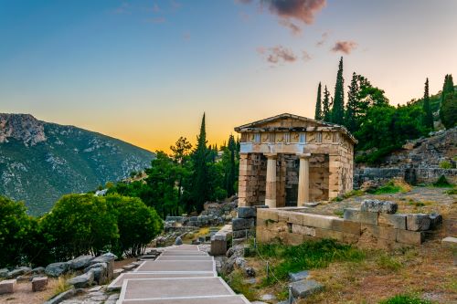 An ancient ruin with towering stone columns surrounded by rugged mountains and a vast valley