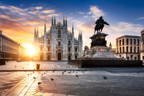 A breathtaking Gothic masterpiece cathedral with an intricate white marble façade and towering spires at sunrise.