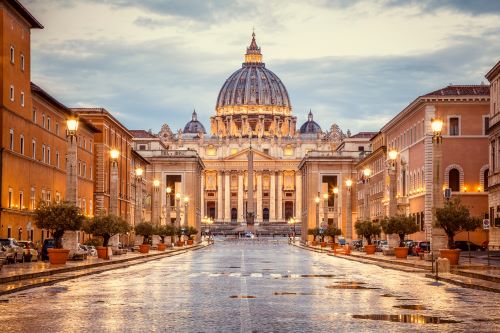 St. Peter’s Basilica lit up at dusk on a rainy day