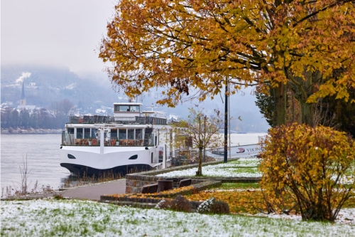 The Viking river vessel at anchor surrounded by autumn-coloured trees with the first snowy layer on and around them