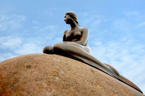 Statue of the little mermaid sat on a rock in copenhagen 