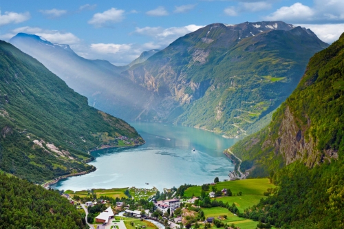 A mystical Scandinavian fjord with the sun throwing rays through the clouds 