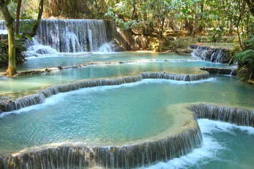 Multi-tiered waterfall with turquoise pools surrounded by lush jungle