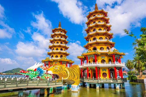 The Dragon Tiger Pagodas in Kaohsiung consisting of two seven storeys tall towers with yellow walls, red pillars and orange tiles, each tower being guarded by a massive dragon and tiger statue. 