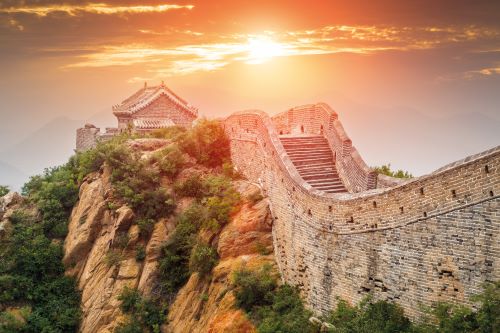 Great Wall of China towards the sun breaking through a cloudy sky 