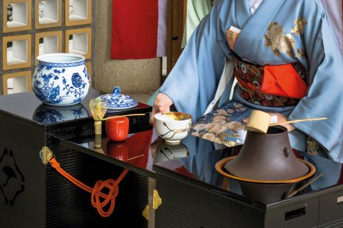 A close up of a Japanese woman performing a tea ceremony 