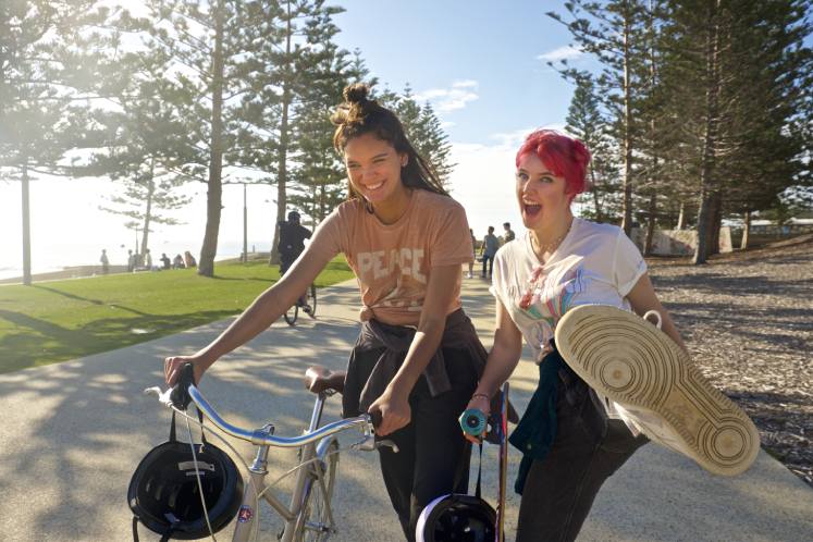 teen girls walking with bike